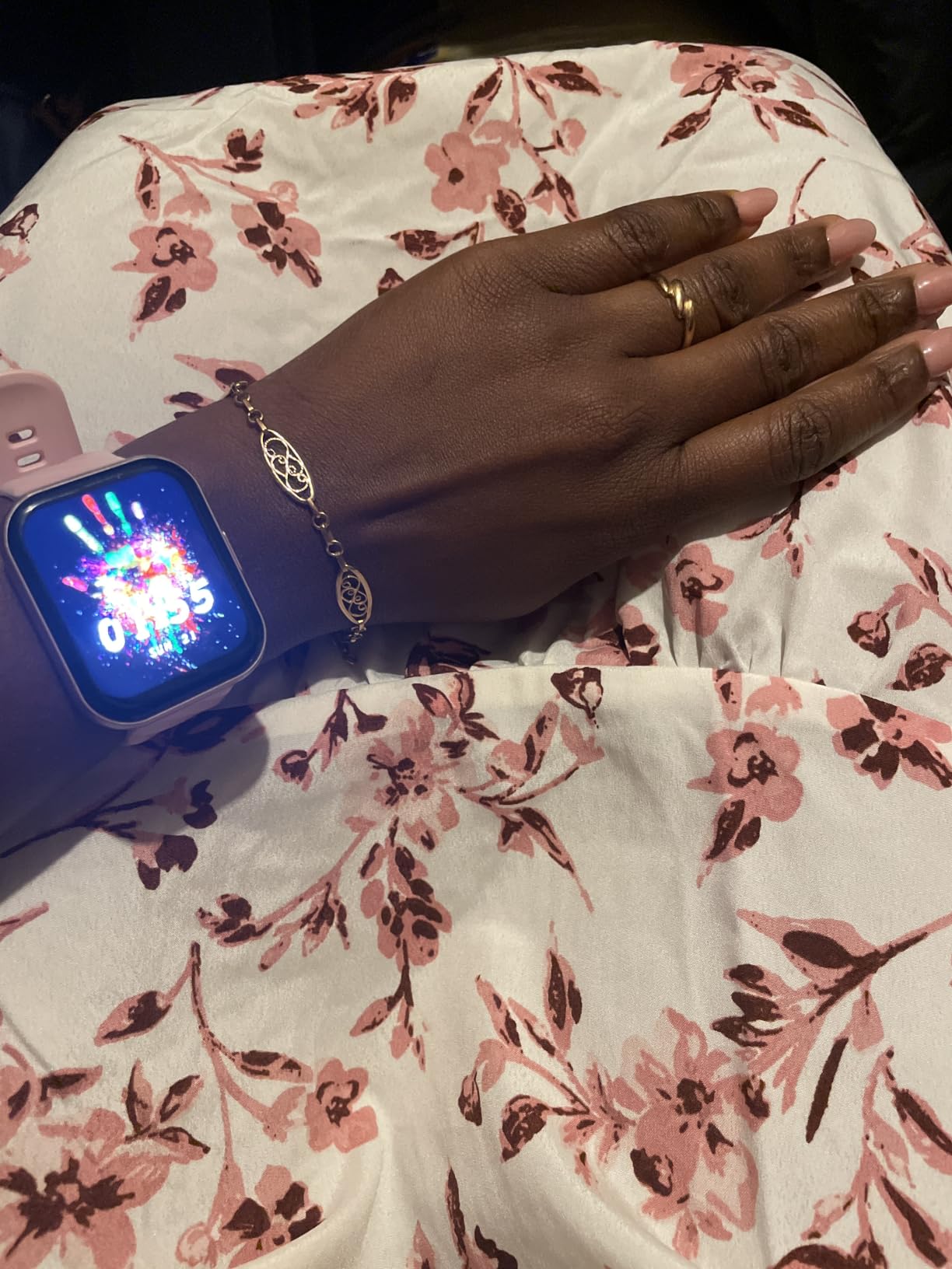 Review photo showing a smartwatch worn with a floral outfit